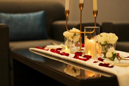 una mesa con una vela y flores en ella en فندق فصل الصيف امان - المنسك, en Abha