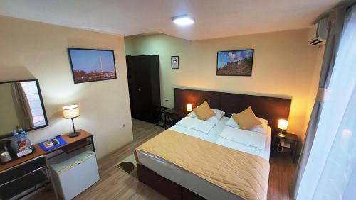 a bedroom with a bed and a desk with two lamps at Hotel Villa Panorama in Belgrade