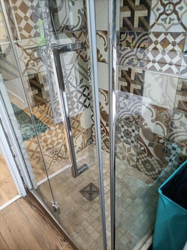 d'une douche avec portes en verre et de carrelage. dans l'établissement Le zéphyr, à Gruissan
