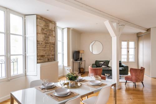 un salon avec une table et des chaises blanches dans l'établissement La Tourelle & l'Honoré - 2 appartements dans le Centre historique de Rennes, à Rennes