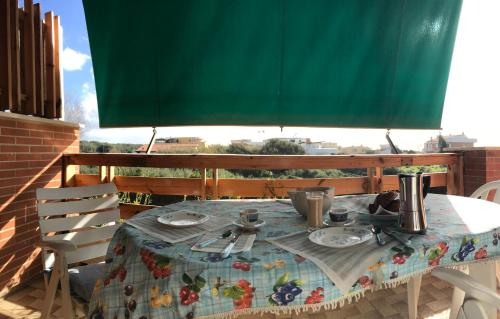 uma mesa com pratos e utensílios num pátio em Stella Di Mare - ampio appartamento con doppi servizi - fronte mare em Lido di Ostia