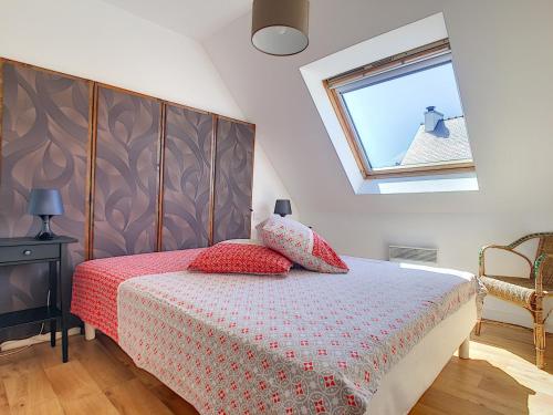 Un dormitorio con una cama con almohadas rojas y una ventana en Maison Roscanvel, 4 pièces, 6 personnes - FR-1-370-52, en Roscanvel