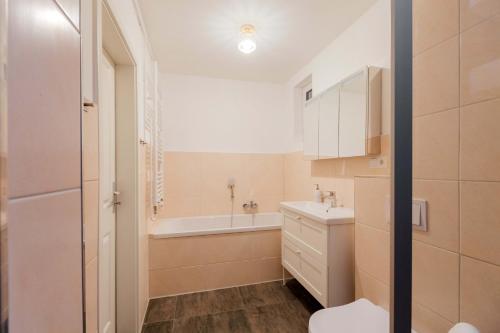 ein Badezimmer mit einer Badewanne, einem Waschbecken und einem WC in der Unterkunft Ferienhaus Caputh Wohlfühlort in Wassernähe in Schwielowsee