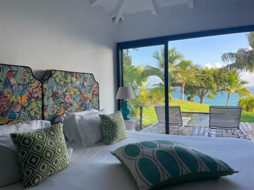 a bedroom with a bed with a view of the ocean at La Toubana Hotel & Spa in Sainte-Anne