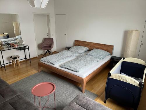 a bedroom with a bed and a chair and a couch at Penthouse perfekt für Teams, Familien und Gruppen in Bad Mergentheim