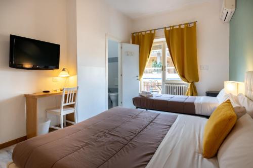 ローマにあるAurelia Home Guest Houseのベッド2台とテレビが備わるホテルルームです。