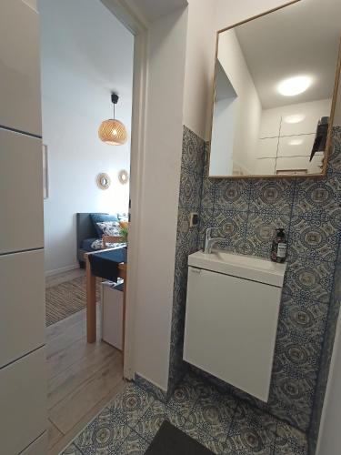 baño con lavabo y espejo en la pared en Lemuria Pokój z łazienką Szkolna en Legnica