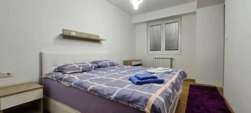ein Schlafzimmer mit einem Bett mit blauen Handtüchern darauf in der Unterkunft Stylish Violet & Modern Apartment in Skopje