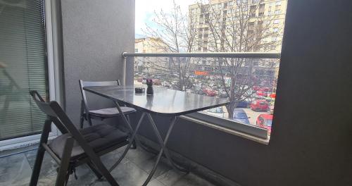 einen Tisch und Stühle in einem Zimmer mit Fenster in der Unterkunft Stylish Violet & Modern Apartment in Skopje
