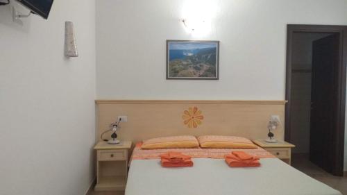 a bedroom with a bed with orange bows on it at Vistamare in Orosei