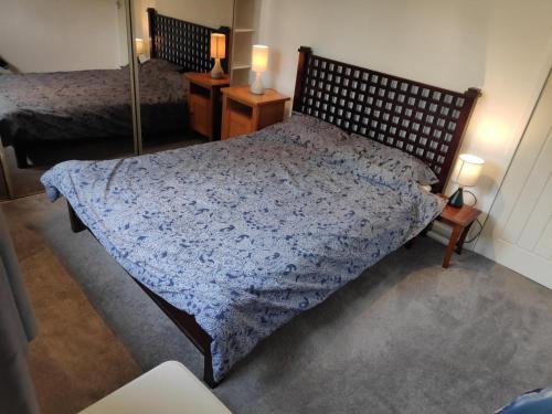 a bedroom with a bed with a blue comforter at Lovely 2BD Flat in picturesque Limekilns Fife in Limekilns