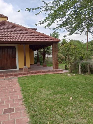 una casa con una pasarela de ladrillo junto a un patio en Los zorzales quinta Chascomus en Chascomús