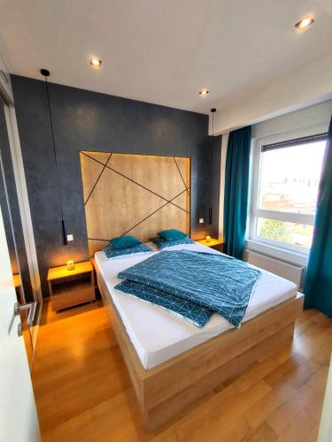 a bedroom with a large bed with blue pillows at Downtown apartment in Banja Luka