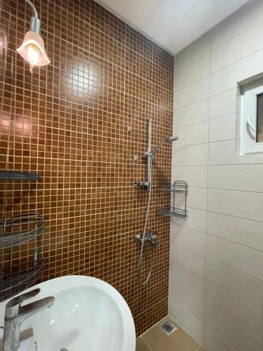 a bathroom with a shower with a sink and a toilet at Al Qalah flats 