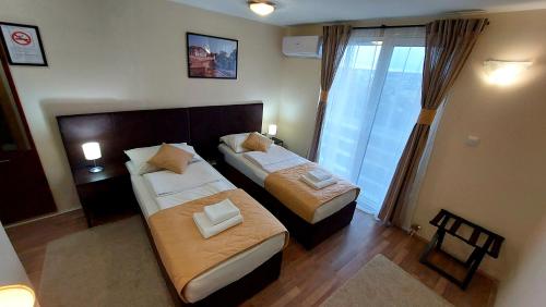 a hotel room with two beds and a window at Hotel Villa Panorama in Belgrade