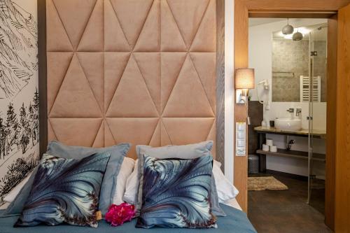 a bedroom with a large headboard and a bed with pillows at Serce Tatr Residence Zakopane - blisko Krupówek in Zakopane