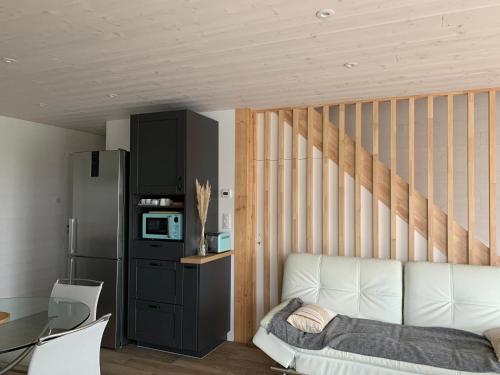 - un salon avec un canapé blanc et un réfrigérateur noir dans l'établissement Gîte du marais, à Beauvoir-sur-Mer