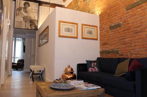 a living room with a couch and a brick wall at Art Apartment Luxury Sofia Suite in Florence