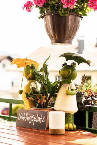 a table with a plant and a pot with two puppets at AKZENT Hotel Bayerwald-Residenz in Neukirchen