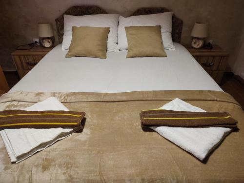 a bed with two towels and two pillows on it at Apartments Blago Sutomore in Sutomore