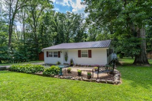 a small white house with a garden in the yard at Blue Mountain Bungalow 