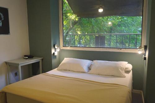 a bed with two pillows in a room with a window at Casa Urbana Hotel in Cordoba