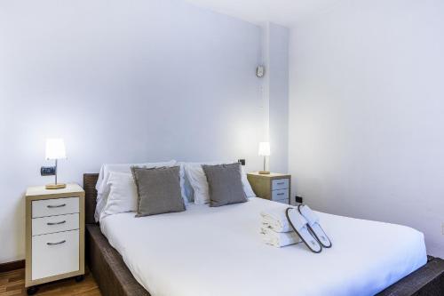 1 dormitorio con 1 cama blanca grande y 2 mesitas de noche en BePlace Apartments in Dateo, en Milán