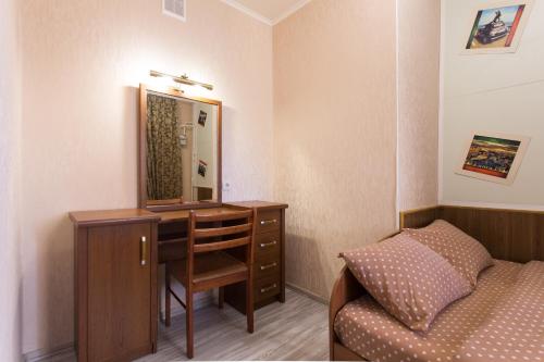 a bedroom with a bed and a dresser with a mirror at Orange House in Kharkiv