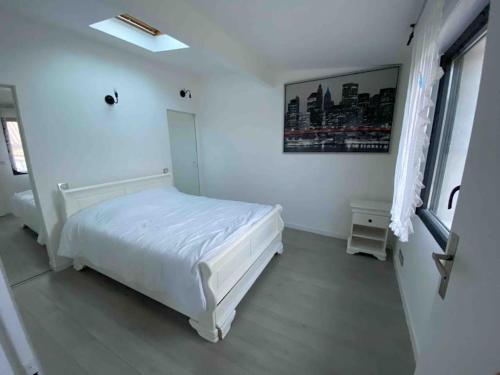 - une chambre blanche avec un lit blanc et une fenêtre dans l'établissement La maison de la pointe rouge, à Marseille