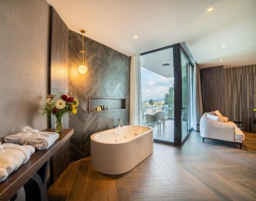 a bathroom with a bath tub and a bedroom at Hotel Pia Bella in Kyrenia