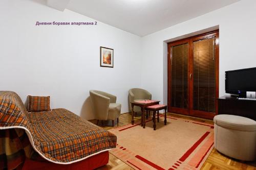a living room with a couch and a tv at Apartmani OKO Zlatibor in Zlatibor
