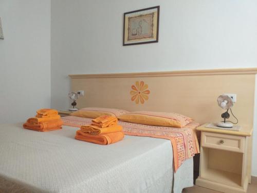 a bedroom with a bed with orange towels on it at Vistamare in Orosei