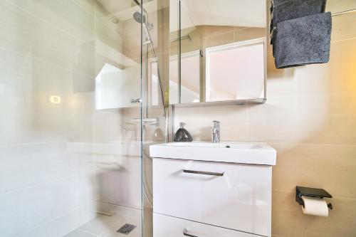une salle de bain blanche avec un lavabo et une douche dans l'établissement MARAIS CHIC heart of Paris, premium location !, à Paris