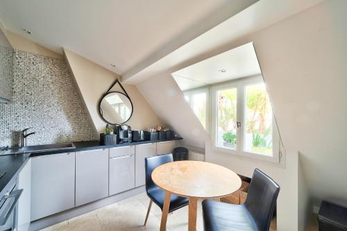 eine Küche mit einem Tisch und Stühlen sowie einem Fenster in der Unterkunft MARAIS CHIC heart of Paris, premium location ! in Paris