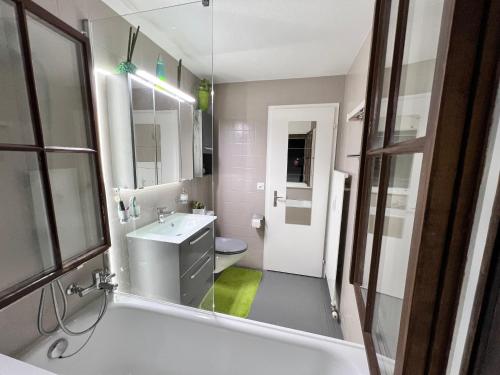 ein Badezimmer mit einer Badewanne, einem Waschbecken und einem WC in der Unterkunft Casa Ucliva - Charming Alpine Apartment Getaway in the Heart of the Swiss Alps in Rueras
