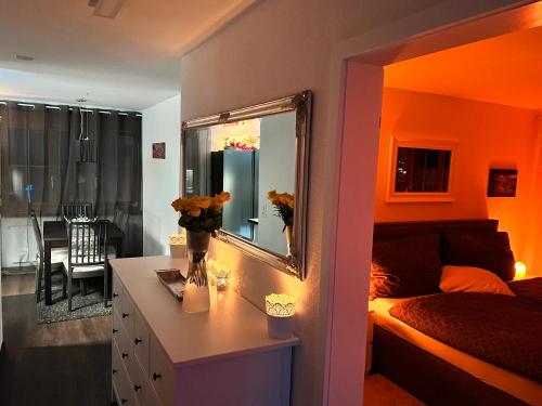 a bedroom with a bed and a dresser with a mirror at Casa Ucliva - Charming Alpine Apartment Getaway in the Heart of the Swiss Alps in Rueras
