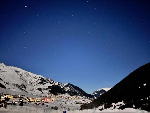 a ski resort at night with snow covered mountains at Casa Ucliva - Charming Alpine Apartment Getaway in the Heart of the Swiss Alps in Rueras