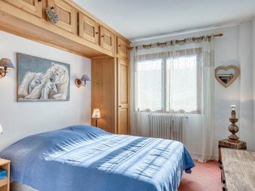 une chambre avec un lit bleu et une fenêtre dans l'établissement Appartement 3 chambres à Megève - Balcon, parking, proche télécabine et centre village - FR-1-453-286, à Megève