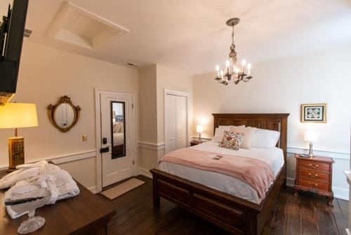 1 dormitorio con cama, mesa y lámpara de araña en Thomas Rose Inn en Lewisburg