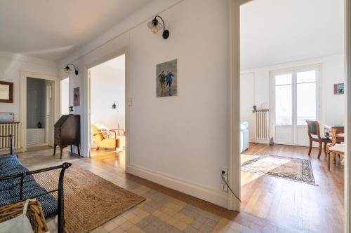 - un salon avec des murs blancs et une chambre avec un canapé dans l'établissement LA SUITE MARCELLIN - Magnifique T3 avec garage et balcon Lyon 7, à Lyon