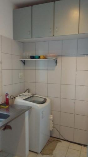 a small kitchen with a washing machine in it at Apartamento com ar-condicionada in Salvador