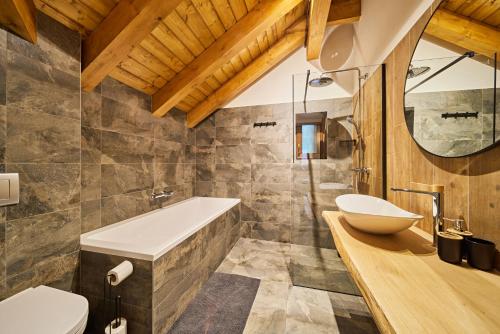 a bathroom with a tub and a sink at Vlčí Stopa Apartments in Pec pod Sněžkou