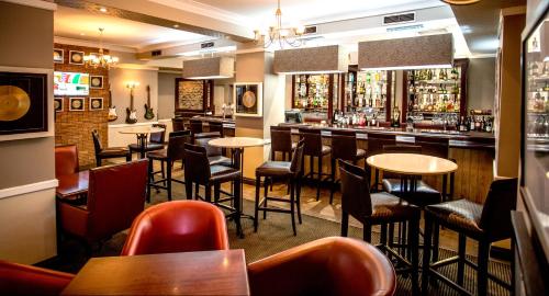 a bar with tables and chairs in a restaurant at Southern Sun Ridgeway Lusaka in Lusaka