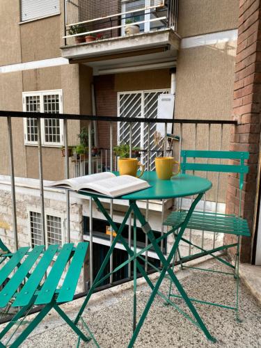 d'une table verte et de deux chaises sur le balcon. dans l'établissement Casa Vacanze Marzia, à Rome