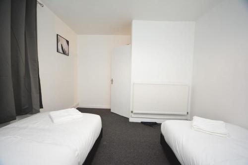 a room with two beds and a radiator at London zone2 Classic 3 bedroom in London