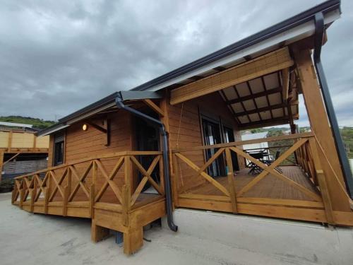 ein großes Holzgebäude mit einer Veranda in der Unterkunft Chalet Iris in Le Lambert