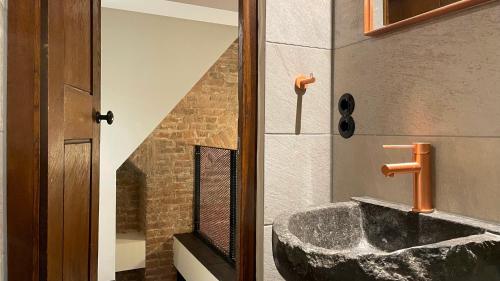 a bathroom with a large rock sink in a room at Walburgis Residenties in Arnhem