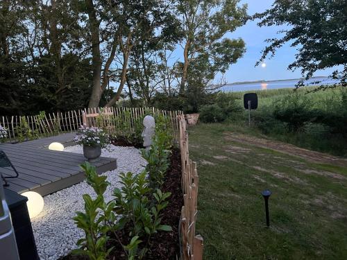 a backyard with a wooden fence and a wooden walkway at Luxuswohnwagen Dreamer mit Achterwasserblick in Lütow