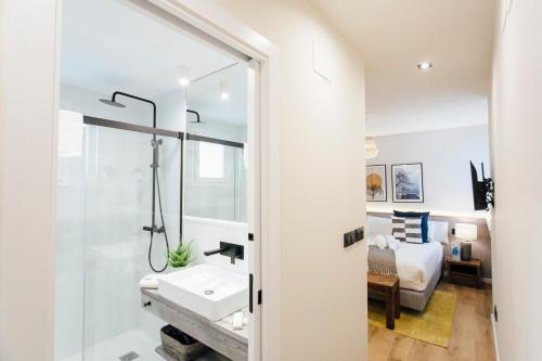 a bathroom with a shower and a sink and a bed at Modern and luxury- 2Bd 2Bth- Socorro in Seville