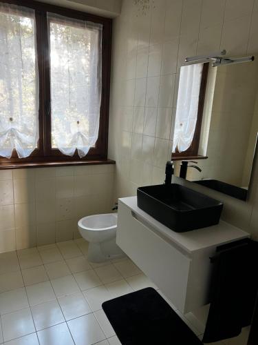 a bathroom with a sink and a toilet and a mirror at Villa Gabry e Villa Fiorita in Camaiore